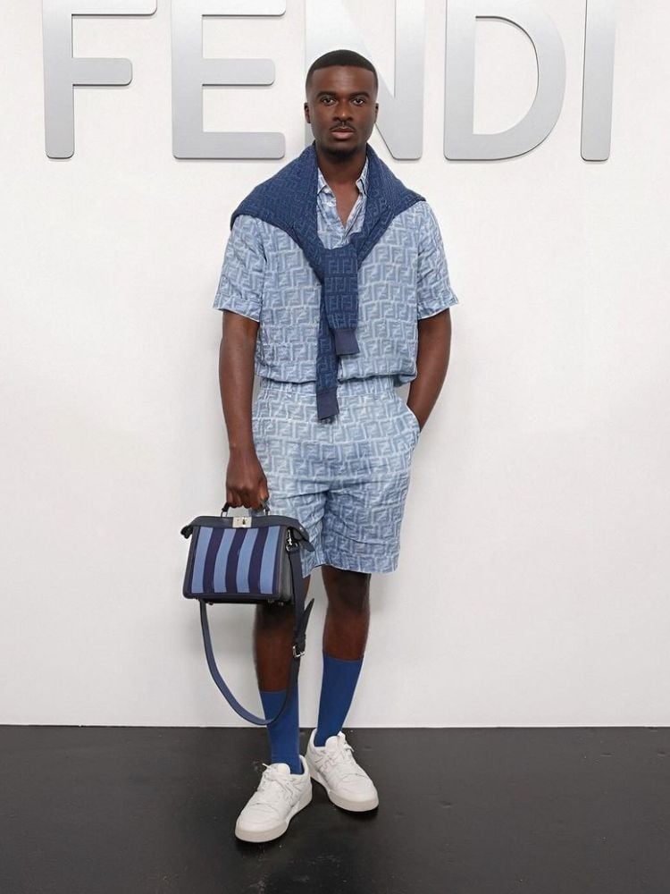 Foto de homem negro com silhueta triângulo usando conjunto de blusa e short azuis estampados da Fendi