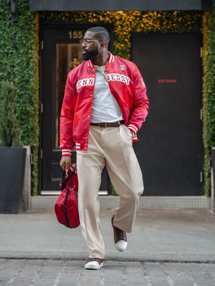 Foto de homem de silhueta oval usando camiseta branca, calça cáqui e jaqueta vermelha