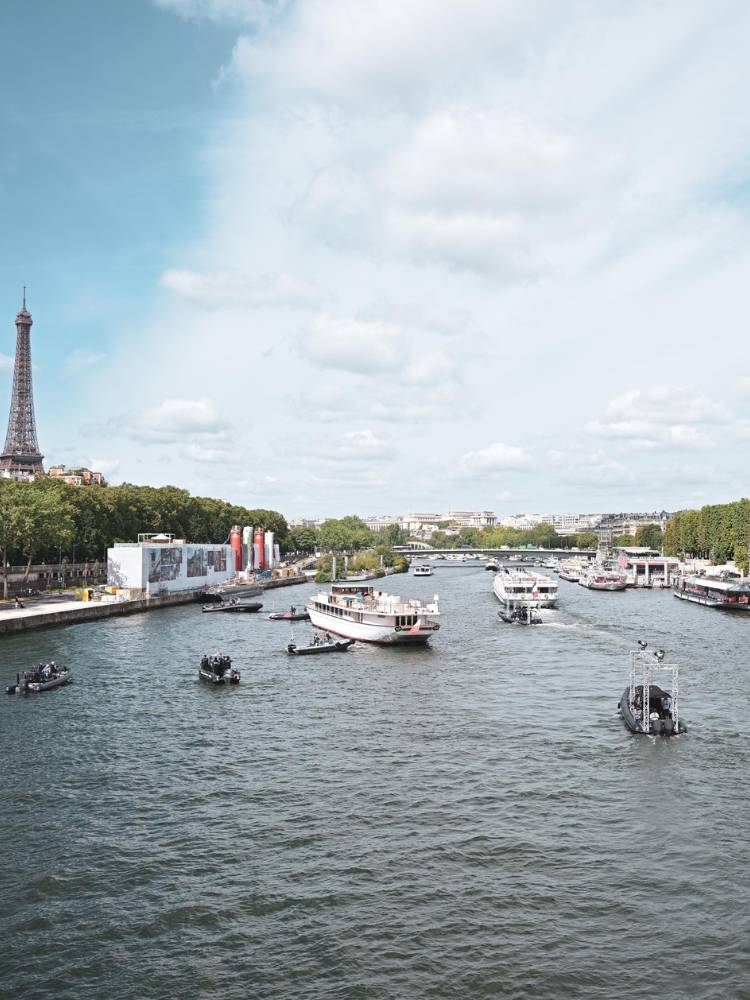 Foto de barcos no Rio Sena com Torre Eiffel ao fundo