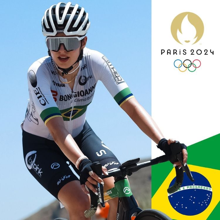 Montagem de Ana Victoria Magalhães pedalando, usando blusa branca, shorts preto, óculos e capacete, com símbolo das Olimpíadas e bandeira do Brasil