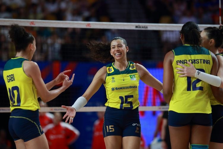 Foto de algumas atletas da seleção brasileira feminina de vôlei comemorando em quadra