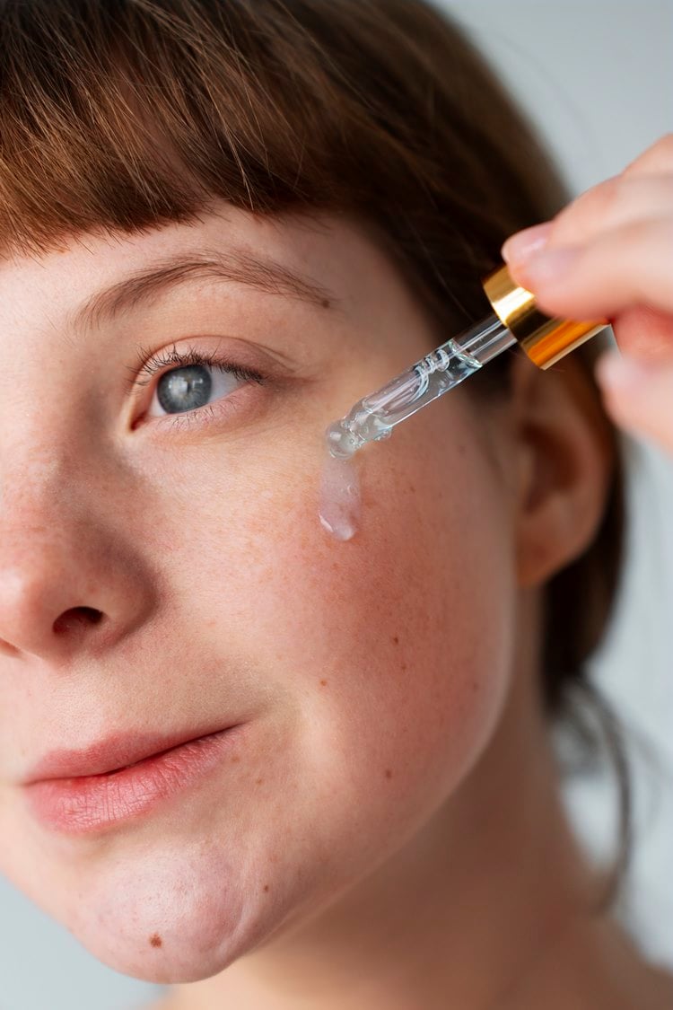 Mulher aplicando sérum em seu rosto na skincare