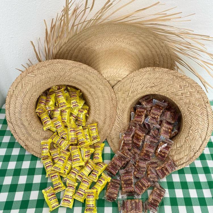 Decoração de festa junina, chapéus de palha com paçoquinha ee doce de amendoim espalhados