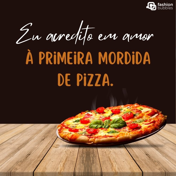 Cartão virtual de fundo preto com pizza sendo colocada  em mesa de madeira, com frase "Eu acredito em amor à primeira mordida de pizza. "