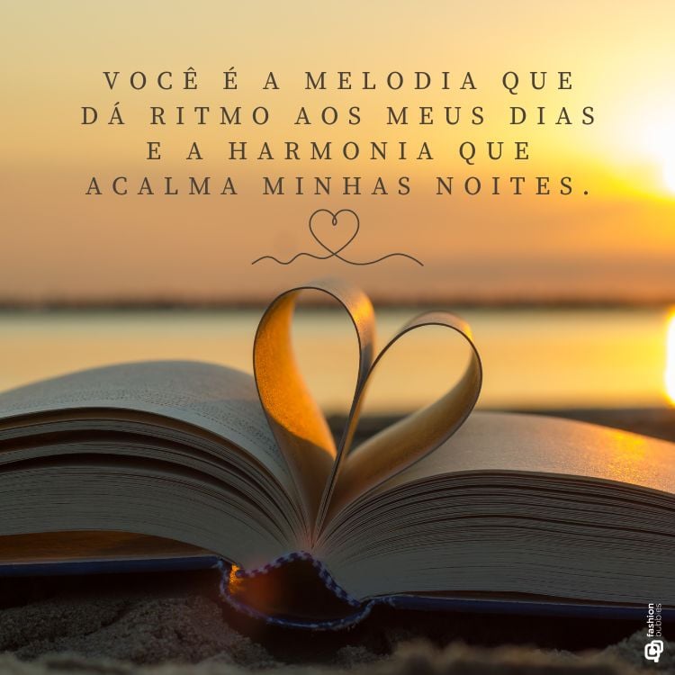 Frase de amor escrita em foto de livro com página dobrada formando coração em praia