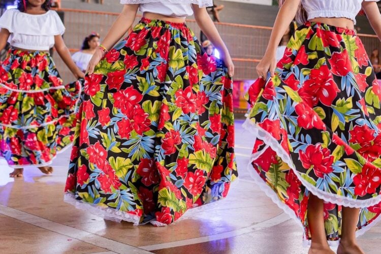 Meninas usando saias longas feitas de chita em quermesse junina