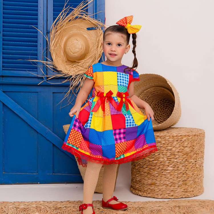 Festa junina infantil: menina com vestido estampa xadrez e laço no cabelo