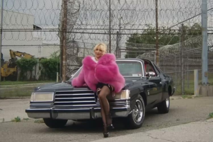 Sabrina Carpenter estrela em seu videoclipe "Please Please Please" usando casaco felpudo pink