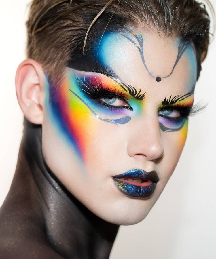 Maquiador LGBT Trevor Barret, com make colorida nos olhos e bochceas, batom metalizado