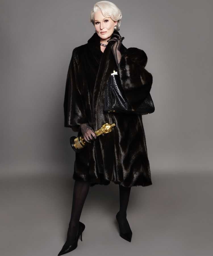 Miranda Priestly usando Casaco de pele escura, meia-calça preta, sapatos pontudos, segurando uma clutch dourada e uma bolsa preta. Elegante e sofisticado na Semana de Alta Costura de Paris inverno 2024