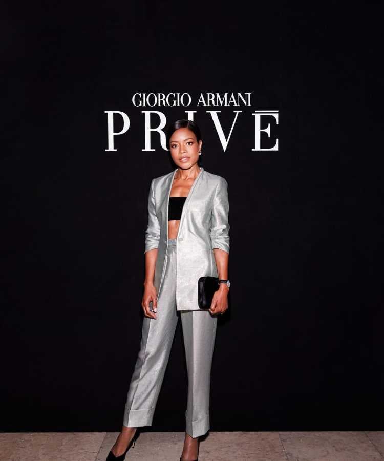 Naomie Harris usando Conjunto prateado Giorgio Armani com blazer recortado, calça preta, salto alto e clutch. Elegante e moderno para eventos formais.