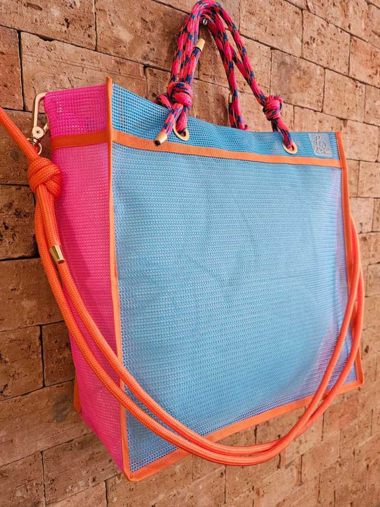 Foto de bolsa feita de sucata nas cores azul e rosa, com alças rosa e laranja