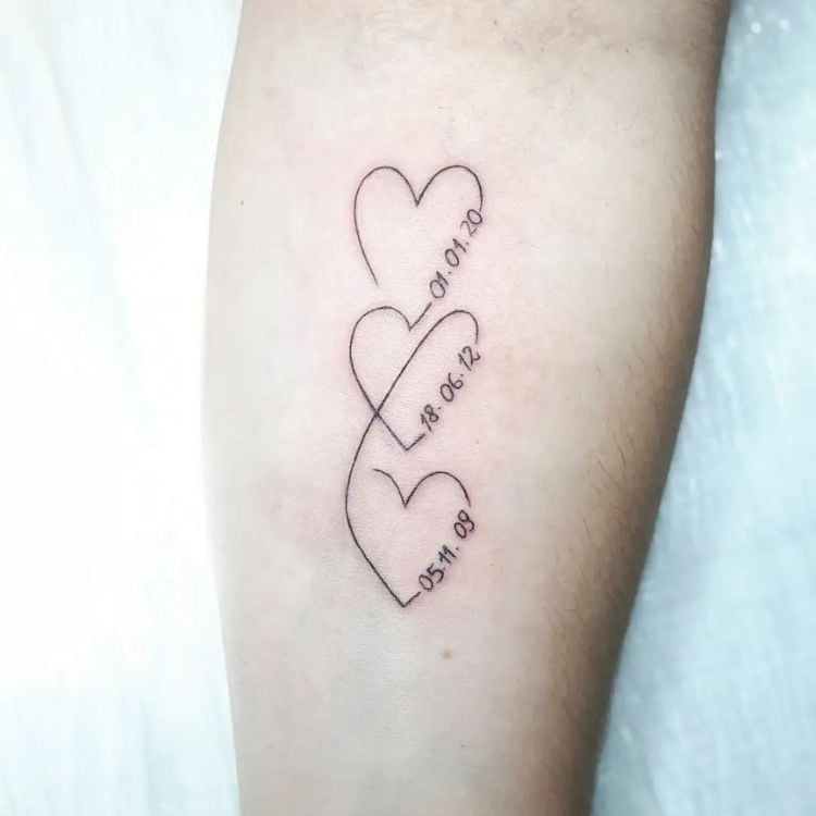 Foto de tatuagem com três corações unidos, com datas de nascimento