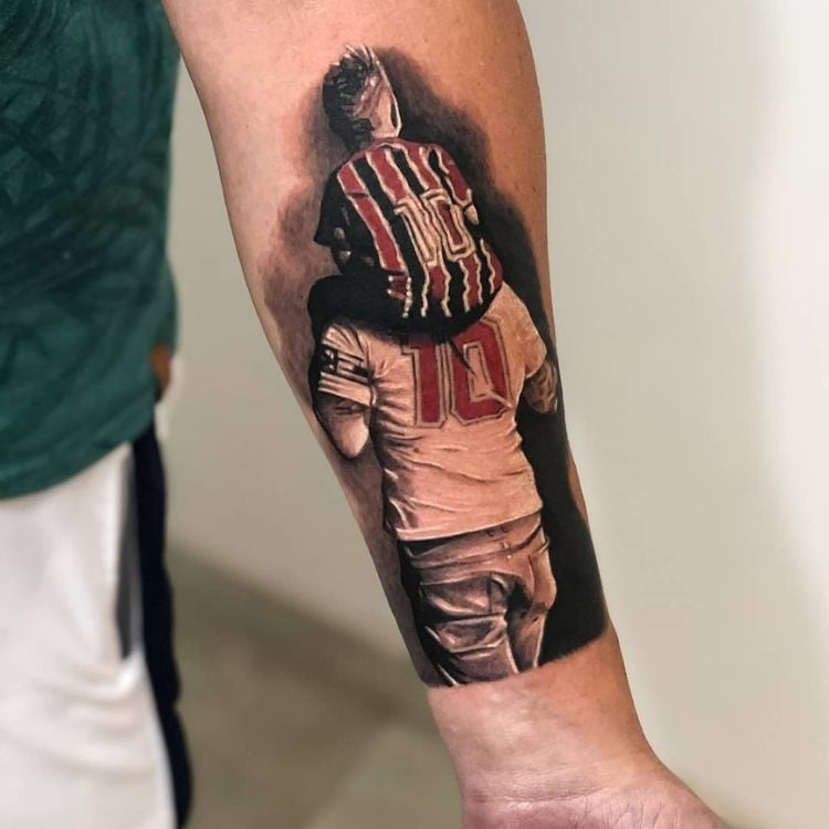 Tatuagem de foto de homem com camisa do São Paulo e filho também com a camisa do São Paulo em seu ombro
