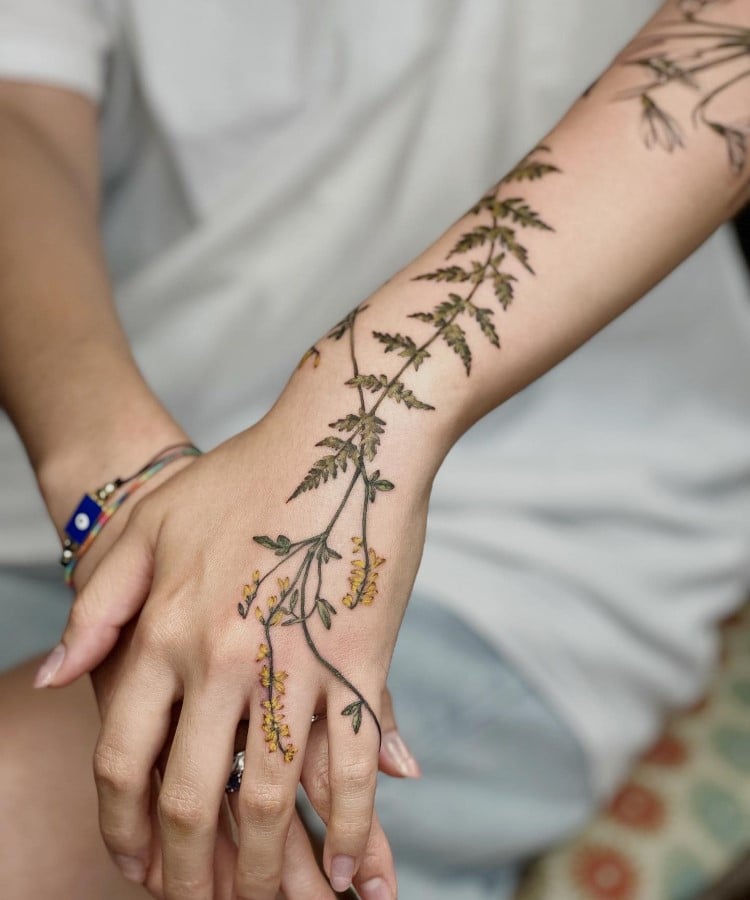 Tatuagem botânica de folhagem floral no na mão e braço