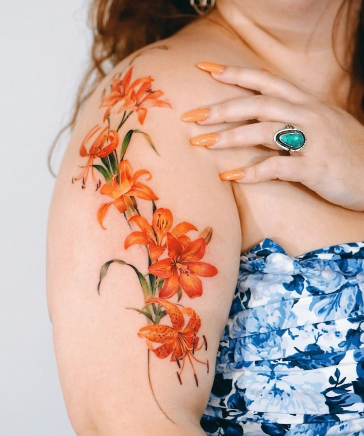 Tatuagem botânica de folhagem floral laranja colorido no braço e ombro