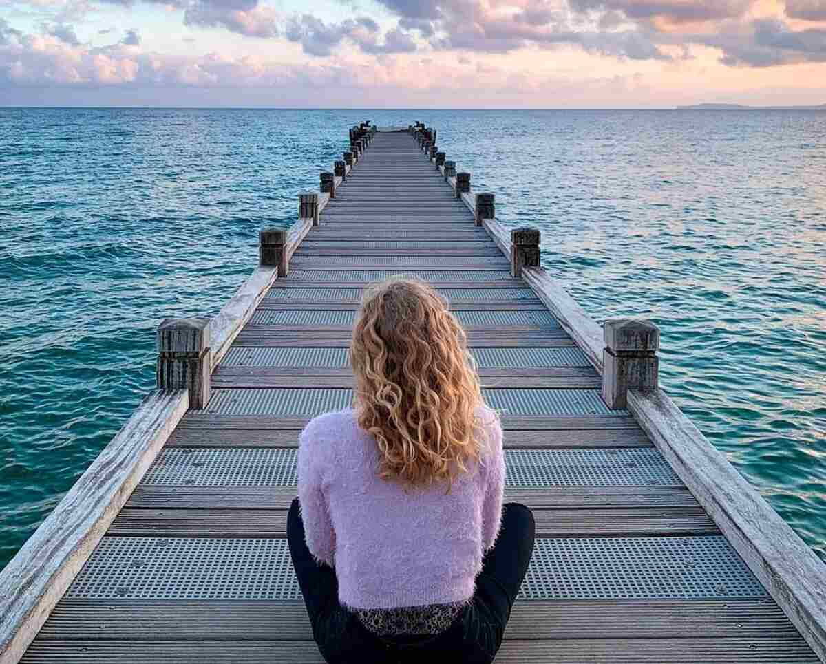 mulher se conectando com a espiritualidade olhando o oceano