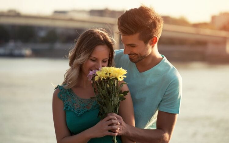 Foto de namorado dando buquê de flores amarelas para surpreender namorada