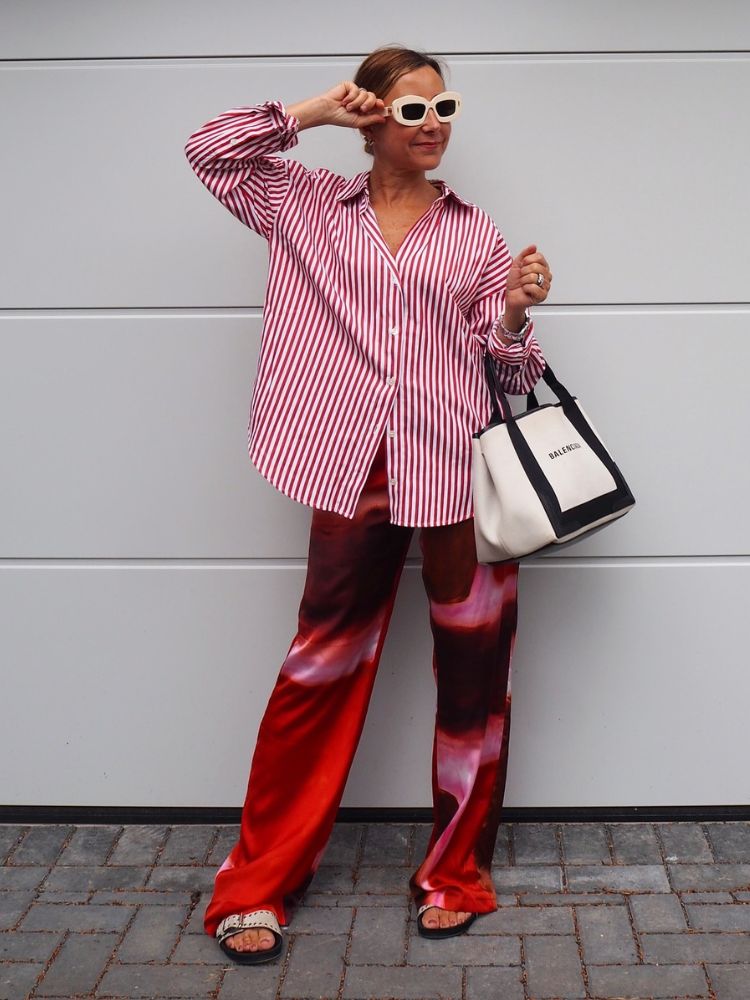 Mulher usando camisa listrada vermelha e branca com calça vermelha estampada