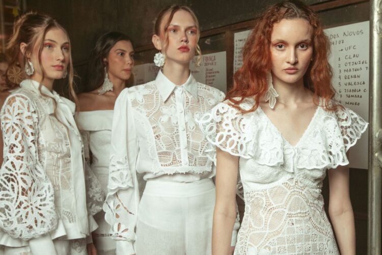 Foto de modelos usando looks de renda brancos, tendência verão 2025, no desfile de Almerinda Maria no DFB