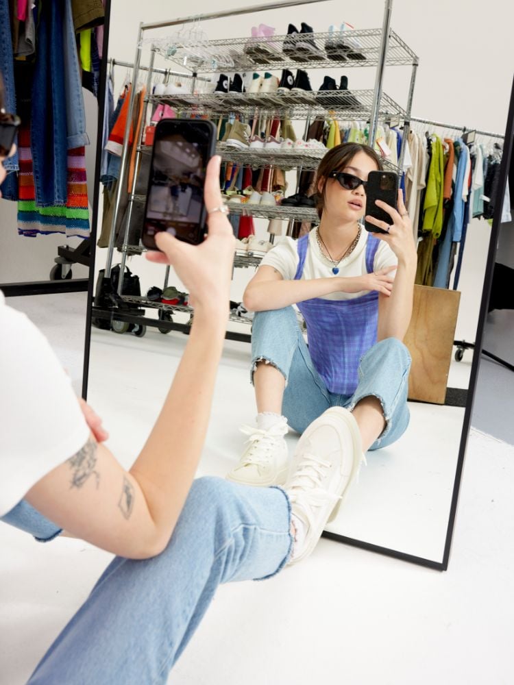 Foto de mulher usando o tênis Converse Chuck Taylor All Star Cruise Ox preto com camiseta branca e jardineira jeans