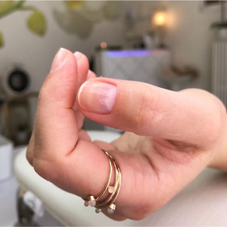 Foto de mão com resultado final da manicure japonesa: unhas naturais, curtas e brilhantes