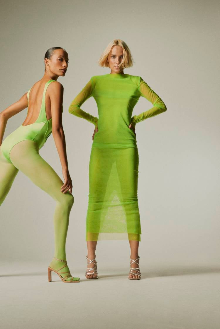 Duas mulheres usando looks verdes, usando saltos de tiras da coleção Santa Lolla Verão 2025