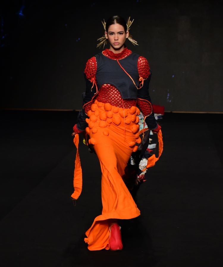 Vestido laranja longo com detalhes fluídos em movimento