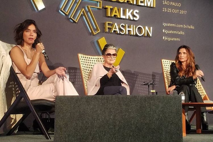 Mulheres sentadas em cadeiras sobre palco palestrando na edição do Iguatemi Talks Fashion 2017