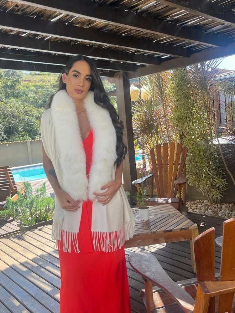 Mulher de pele clara usando vestido vermelho e xale branco com lã e pele