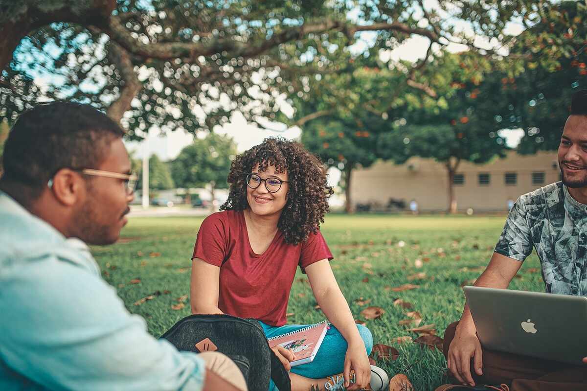 Pessoas felizes conversando e trabalhando na grama