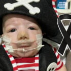 Filho de Zé Vaqueiro usando roupinha de pirata. O bebê faleceu dia 09 de julho. Símbolo de luto