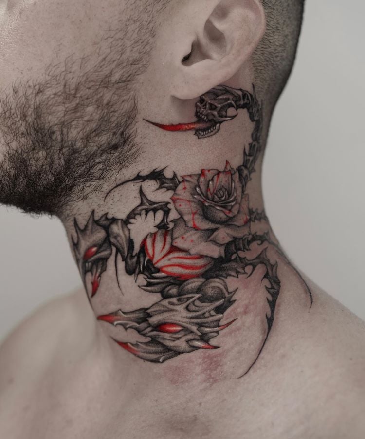 A imagem mostra uma pessoa de costas, com cabelo curto e barba. Ela tem uma tatuagem no pescoço de dois dragões simétricos, com detalhes em vermelho e preto. A tatuagem começa na base do pescoço e se estende até a parte superior das costas. 