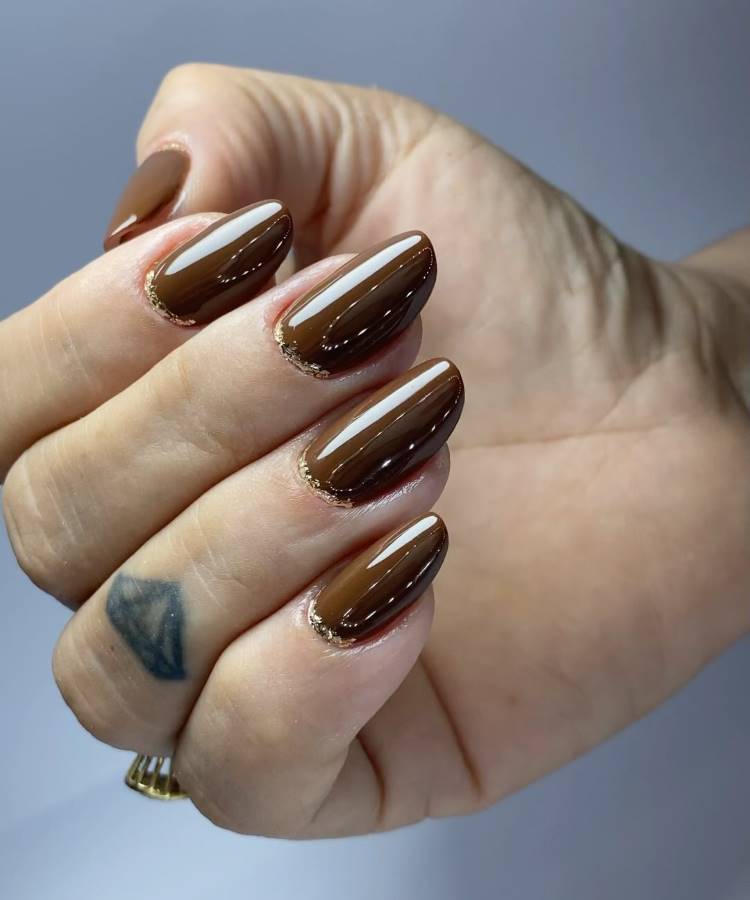 Unhas marrom com detalhes de glitter dourado na cutícula