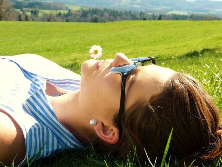 Mulher trabalhando meditação e intuição deitada na grama