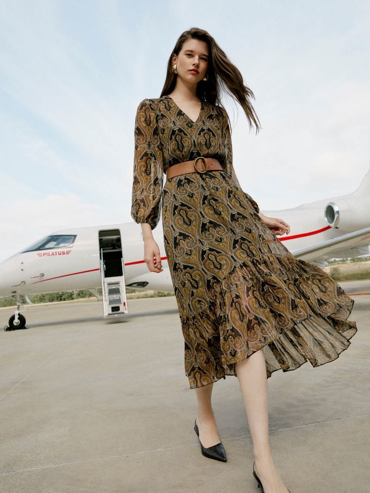 Modelo em aeroporto usando vestido estampado da coleção Jet Set, da Amissima Verão 2025