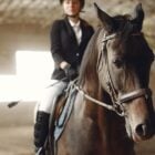 Mulher montada em cavalo praticando esportes equestres