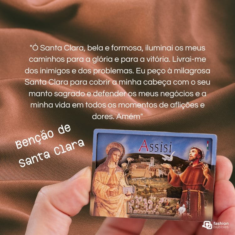 A imagem mostra uma mão segurando um cartão com uma pintura de Santa Clara e São Francisco de Assis. O fundo é um tecido marrom. O texto diz: "Ó Santa Clara, bela e formosa, iluminai os meus caminhos para a glória e para a vitória... Benção de Santa Clara."A imagem mostra uma mão segurando um cartão com uma pintura de Santa Clara e São Francisco de Assis. O fundo é um tecido marrom. O texto diz: "Ó Santa Clara, bela e formosa, iluminai os meus caminhos para a glória e para a vitória... Benção de Santa Clara."