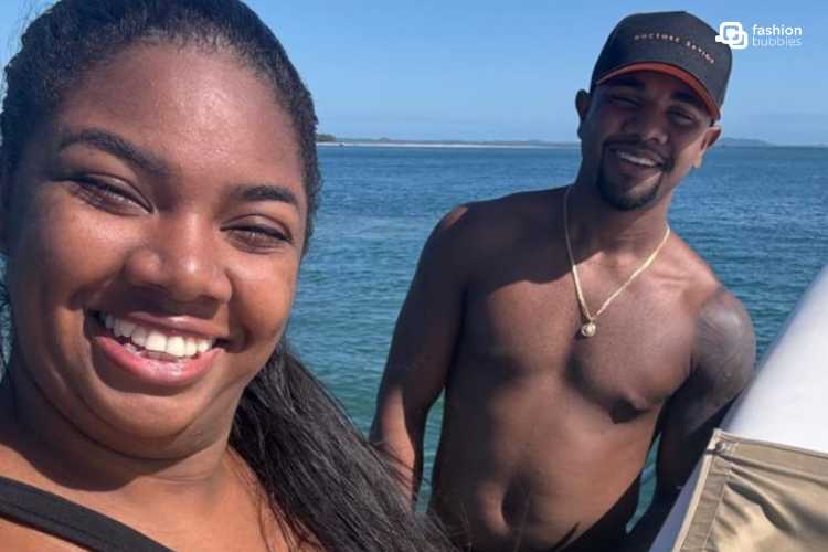 Raquel Brito e Davi Brito juntos, com o mar de fundo. Ambos são negros e sorriem para a foto