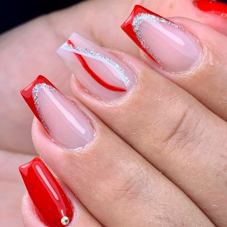 Unhas bailarinas transparentes com francesinha vermelha com glitter no anelar e indicador, esmalte vermelho no mindinho e traços vermelhos e prateados no médio 