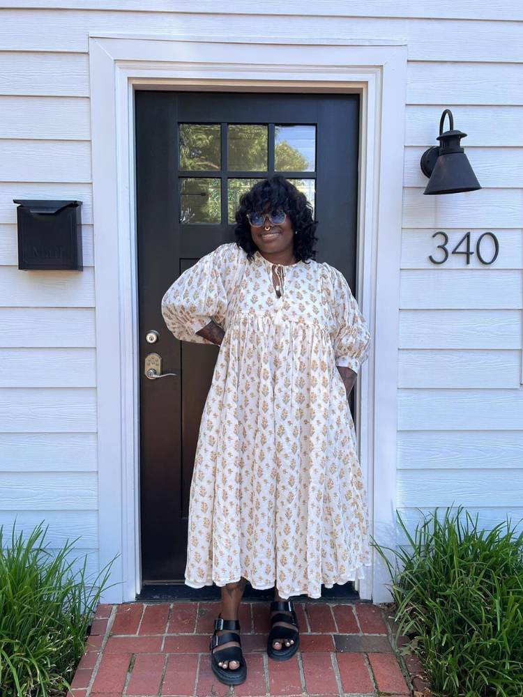 Mulher de pele negra usando vestido boho chic bege 