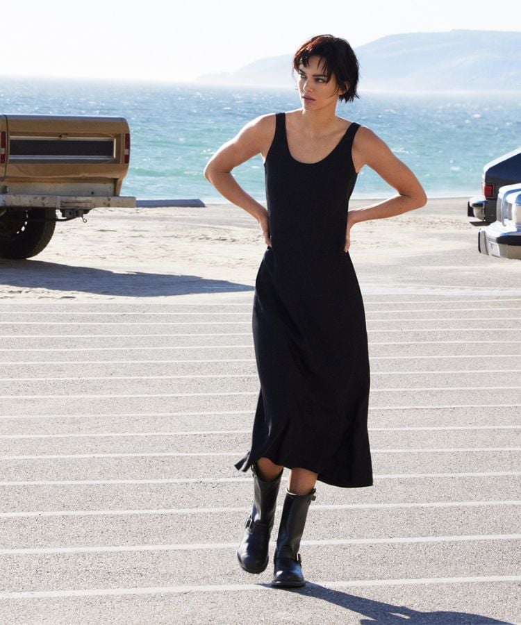 Modelo usando slip dress preto com bota coturno da mesma cor