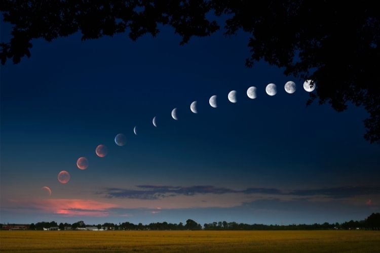 Foto dos vários estágios de um eclipse lunar em céu azul escuro