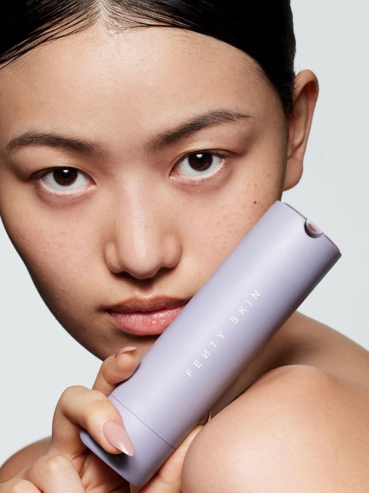 Mulher asiática com produto da Fenty Skin