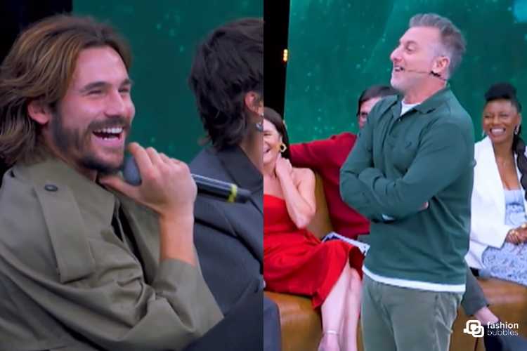 Nicolas Prattes tem cabelo comprido, claro, barba e sorri. Luciano Huck tem barba branca, cabelo grisalho, usa roupa verde e está em pé.