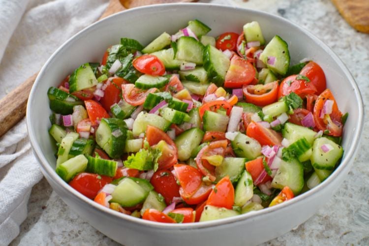 Foto de salada de pepino com tomate, cebola e temperos em bowl branco 