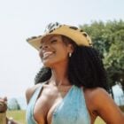 Suelen Gervásio usando chapéu de cowboy e top jeans com paisagem de campo atrás