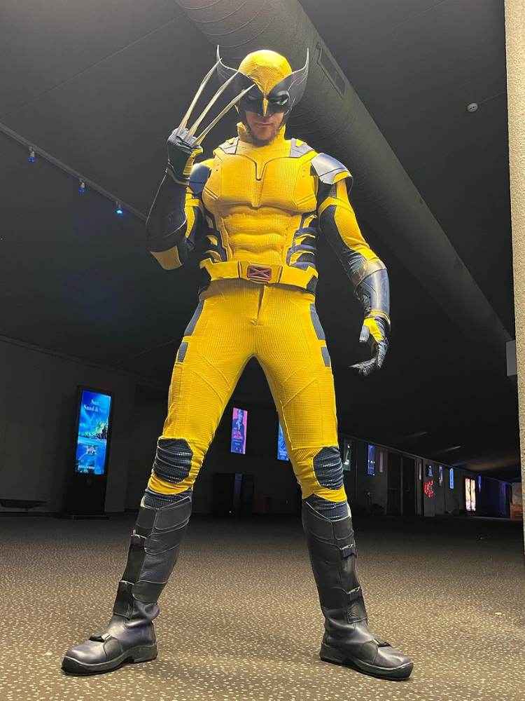 Pessoa fantasiada de Wolverine, com macacão amarelo e garras 