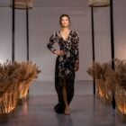 Foto de modelo em desfile de moda em São Paulo e Madri usando vestido longo preto com bordados em prata