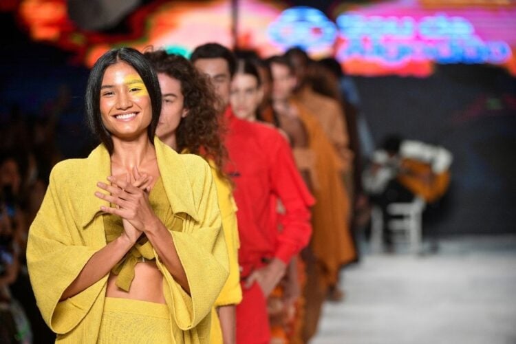 Foto do desfile da Sou de Algodão no SPFW de 2022, com modelo usando conjunto amarelo na frente da fila